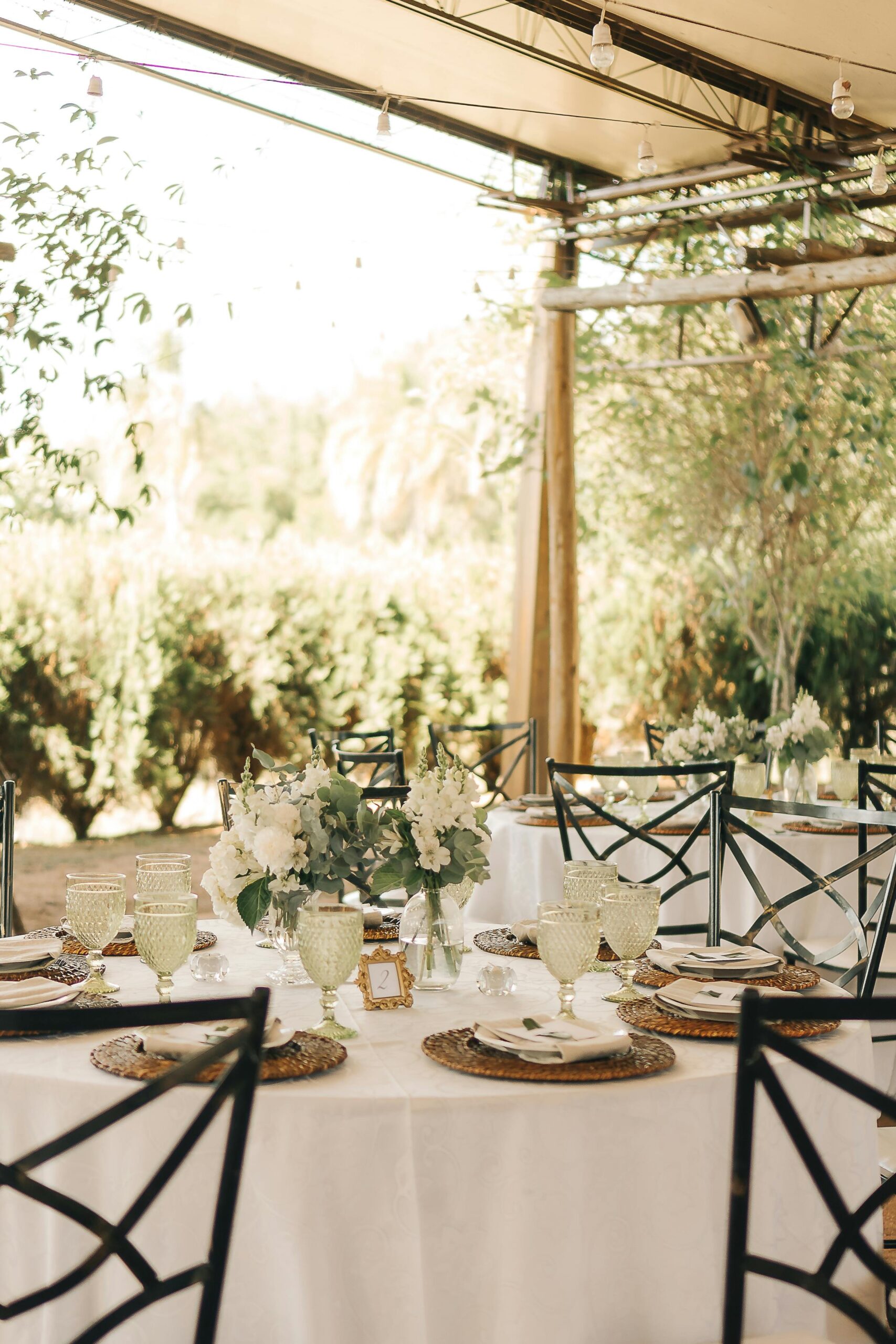Beautiful outdoor wedding reception setup with elegant table decor and floral centerpieces.